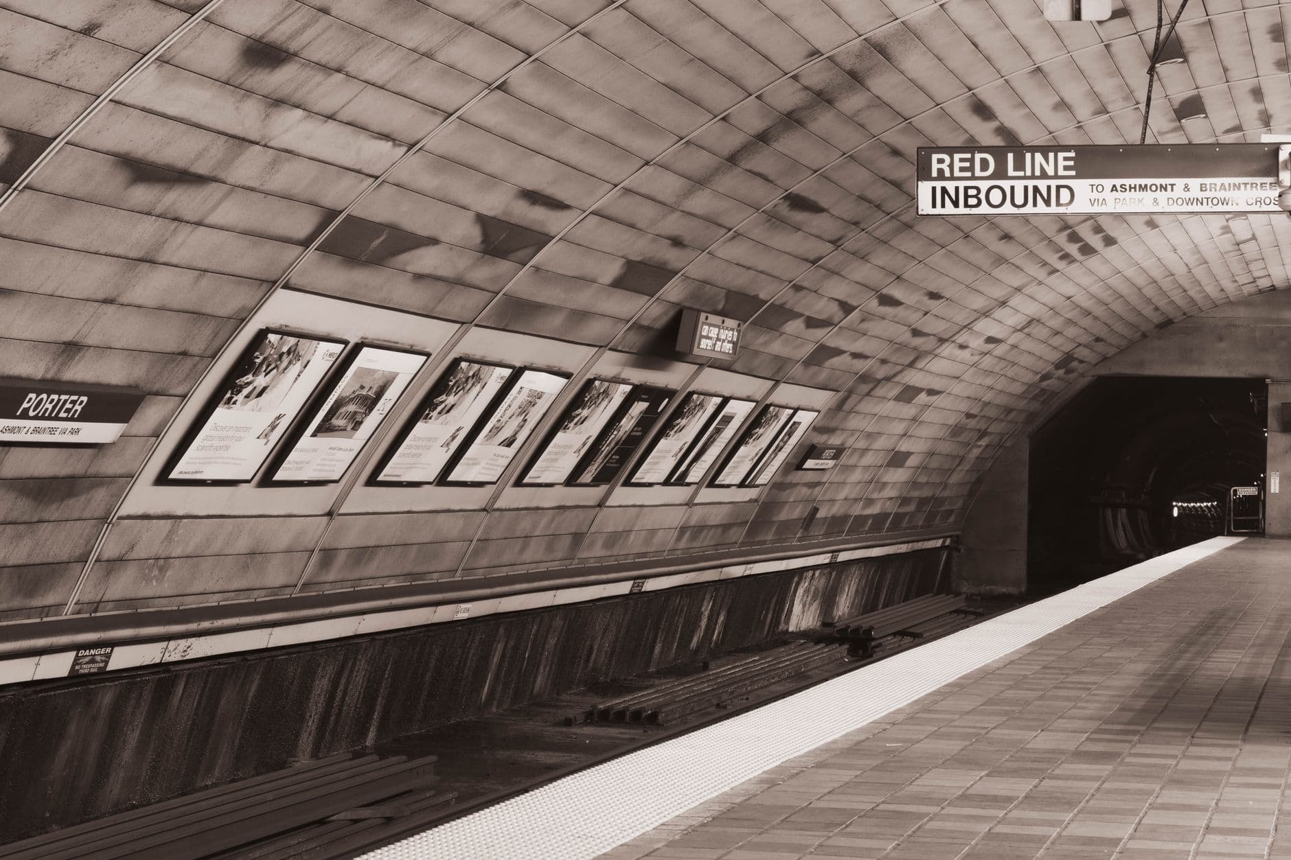 A deserted subway station platform with a view into the tunnel. Sepia tone adds a vintage feel.